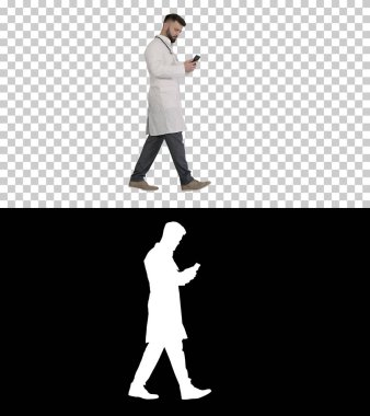 Beyaz üniformalı bir erkek doktor. Yürüyor ve akıllı telefon kullanıyor.