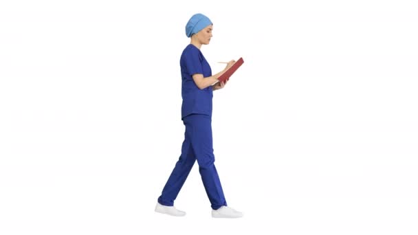 Médico profesional femenino haciendo notas en el diario médico mientras camina, Alpha Channel — Vídeos de Stock