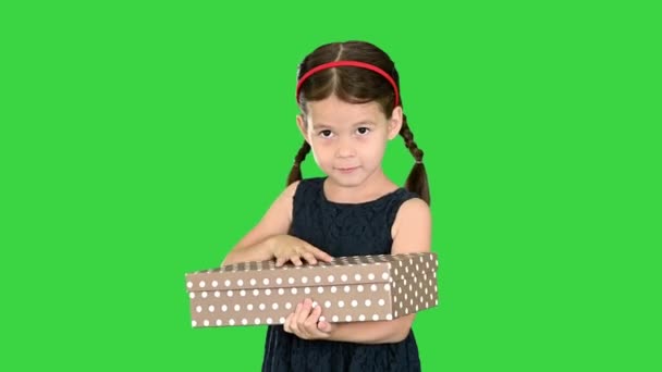 Chica feliz en vestido negro temblando y abriendo la caja de regalo sonriendo a la cámara en una pantalla verde, Chroma Key. — Vídeo de stock