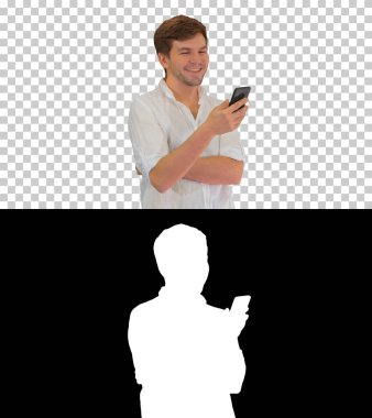 Akıllı telefonunu kullanıp gülen yakışıklı genç adam, Alpha Chan.