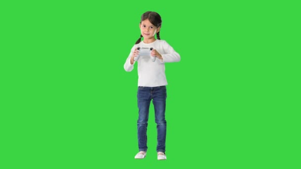 Emocionada niña jugar videojuego con joystick en sus manos en una pantalla verde, Chroma Key. — Vídeo de stock