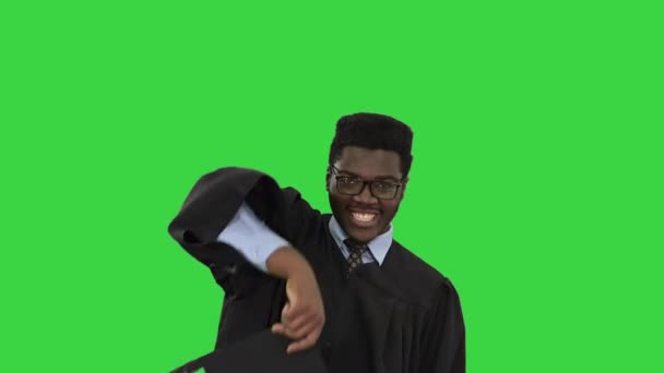 Eccitato studente afroamericano maschio gettando mortai in aria e facendo danza sciocca con il suo diploma su uno schermo verde, Chroma Key. — Video Stock