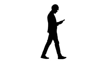 Siluet Genç mimar yürürken ders kitabı ya da defter okuyor.