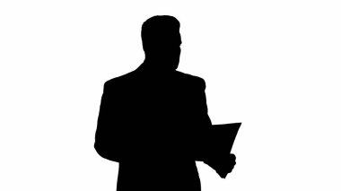 Siluet İşadamı yürüyor ve saat planının denetiminde.