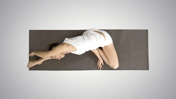 Vacker ung kvinna klädd i vita kläder gör yoga motion — Stockfoto