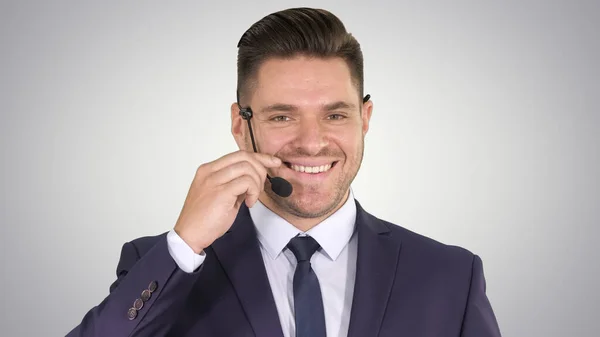 Hombre de negocios guapo con auriculares mirando a la cámara y sonriendo — Foto de Stock