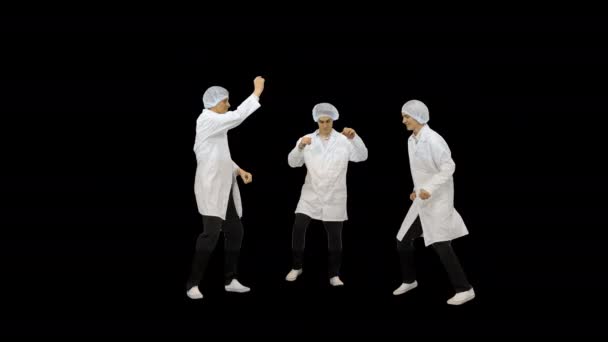 Tre manliga läkare i vita morgonrockar och skyddshattar gör roliga fest dans, Alpha Channel — Stockvideo