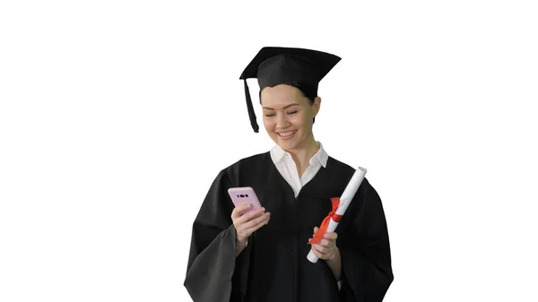 Happy female graduate holding diploma and texting on her phone o — Stock Photo, Image