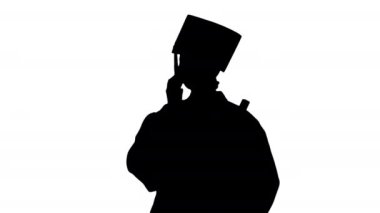 Mezuniyet cüppeli duygusal kız öğrenci telefonda diplomasıyla konuşuyor..