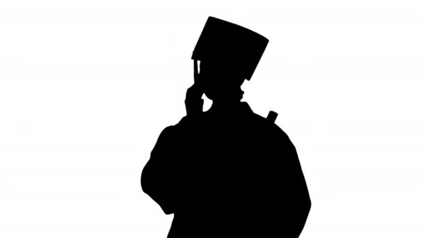 Silhouette Studentessa emotiva in accappatoio di laurea parlare al telefono in possesso di diploma. — Video Stock