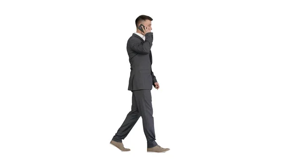 Empresário andando e falando no celular no backgro branco — Fotografia de Stock