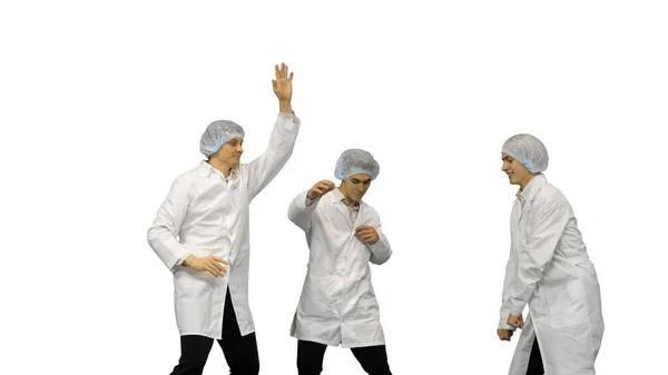 Drie mannelijke dokters in witte gewaden en beschermhoeden doen funn — Stockfoto