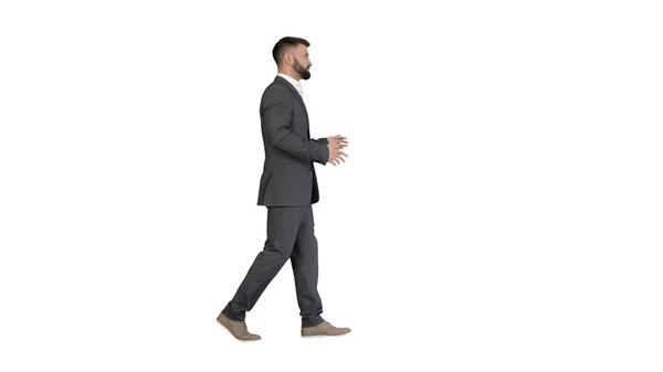 Brodatego biznesmena spacerującego i wyjaśniającego coś na białej ba — Zdjęcie stockowe
