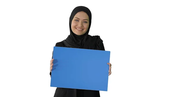 Leende arabiska kvinna i hijab hålla tom blå affisch och lookin — Stockfoto