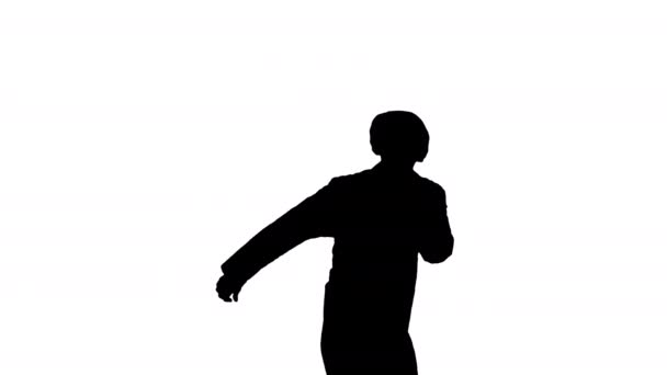 Silhouette Joven doctor masculino en bata blanca y gorra protectora bailando danza moderna mirando a la cámara. — Vídeos de Stock