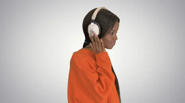 Smiling african american woman with headphones walking listening — Stock Photo, Image