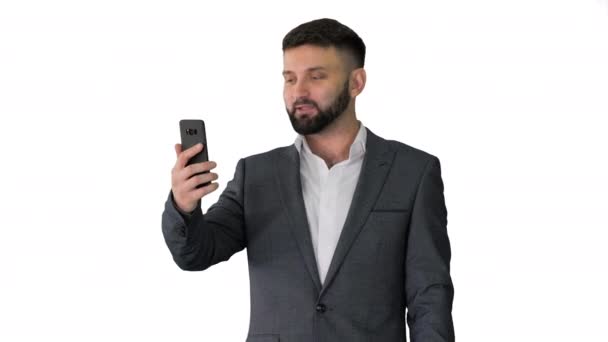 Podnikatel dělat video hovor se svým smartphonem na bílém pozadí. — Stock video