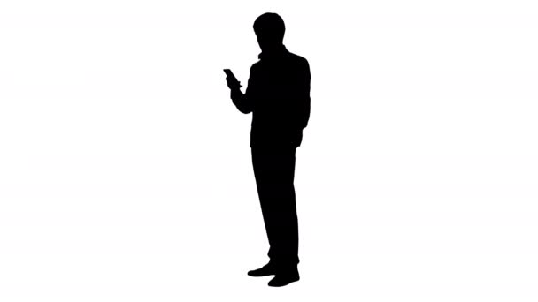 Silhouet Ernstige zakenman op zoek naar zijn telefoon. — Stockvideo
