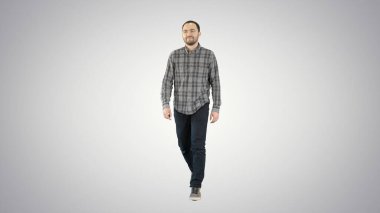 Genç adam, iyi bir ruh hali içinde, değişken arka planda yürüyor..