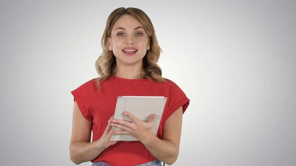 Mujer presentadora en camiseta roja sosteniendo una tableta pasando páginas un — Foto de Stock