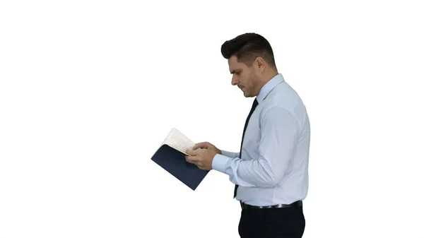 Young confused man trying to read smart book misunderstanding content while walking on white background. — Stock Photo, Image