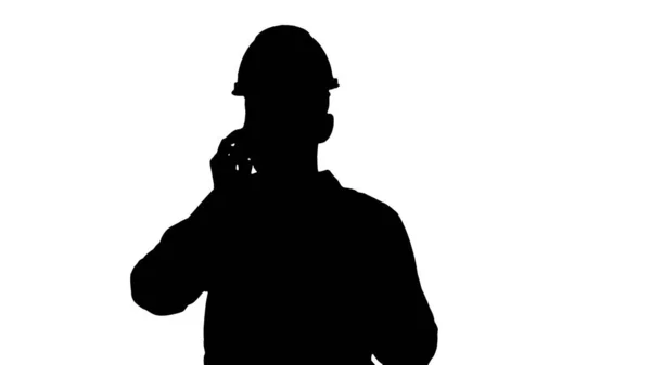 Beyaz gömlekli ve kasklı bir mühendis cep telefonuyla konuşuyor. — Stok fotoğraf