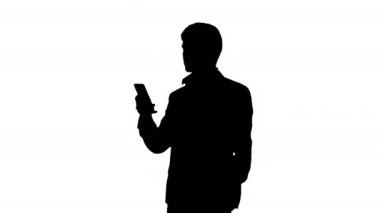 Siluet ciddi iş adamı telefonuna bakıyor..