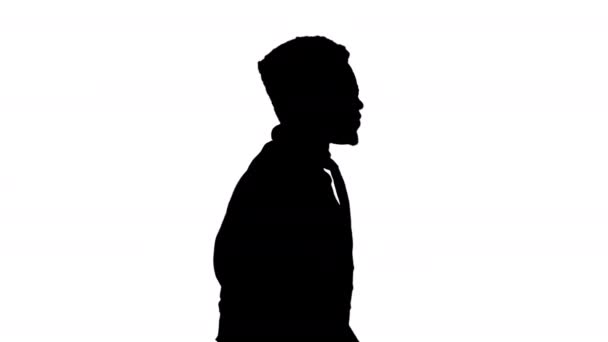 Silhouette自信を持ってアフリカ系アメリカ人ビジネスマンが眼鏡をかけ、まっすぐ前を向いて歩くネクタイ. — ストック動画