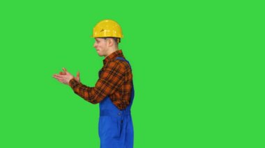 İnşaat işçisi takla atıyor ve kameraya bakıyor Yeşil Ekran 'daki en iyi inşaat konsepti, Chroma Key.