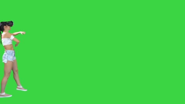 Mulher usando realidade virtual fone de ouvido andando e dançando em uma tela verde, Chroma Key. — Vídeo de Stock