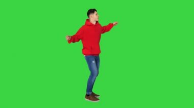 Yeşil ekranda kırmızı kapüşonlu dans eden yakışıklı genç adam, Chroma Key.