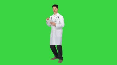 Çekici kendine güvenen doktor yeşil ekrandaki sonuçları okuduktan sonra tabletle dans ediyor, Chroma Key.