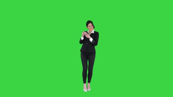 Joven mujer de negocios escuchando música en el teléfono y bailando en una pantalla verde, Chroma Key. — Vídeo de stock