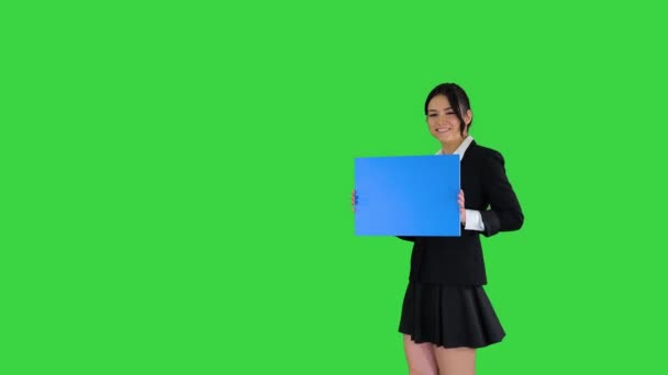 Linda chica sosteniendo tablero vacío anunciando o presentando algo en una pantalla verde, Chroma Key. — Vídeos de Stock