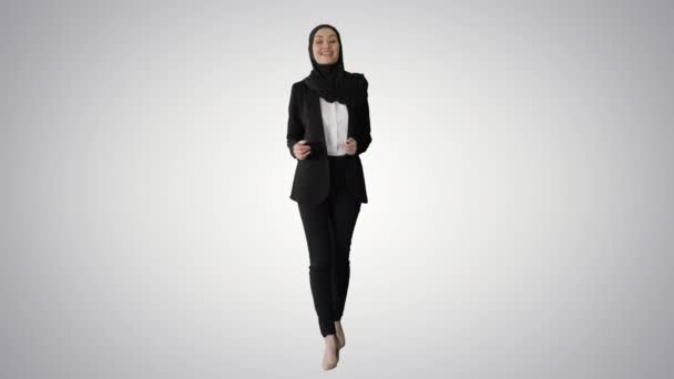 Leende arabiska kvinna bär hijab talar om affärer medan promenader och gester på lutning bakgrund. — Stockvideo