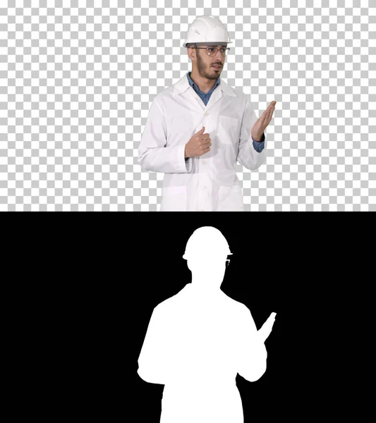 Cientista em roupão branco e capacete apresentando apontando para o lado w — Fotografia de Stock