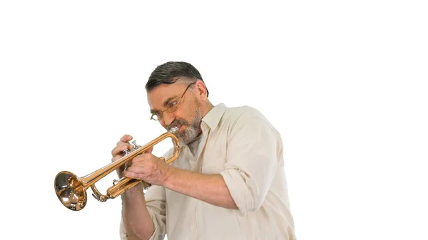 Öreg ember szemüvegben játszik trombita fehér háttér. — Stock Fotó
