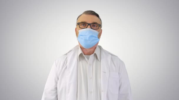 Lekarz w masce medycznej przeciwko Coronavirus Covid-19 oddycha intensywnie na gradientowym tle. — Wideo stockowe
