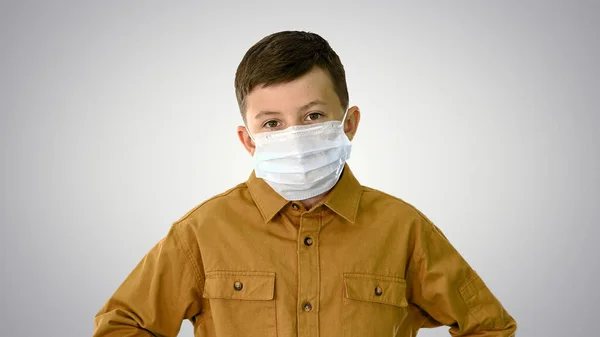 Niño con mascarilla protectora mirando a la cámara en gradiente b — Foto de Stock