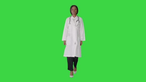 Traurige afroamerikanische Ärztin, die mit den Händen in den Taschen auf einem Green Screen, Chroma Key, wandelt. — Stockvideo