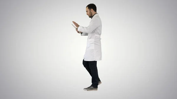 Médico usando guia enquanto caminha sobre fundo gradiente. — Fotografia de Stock