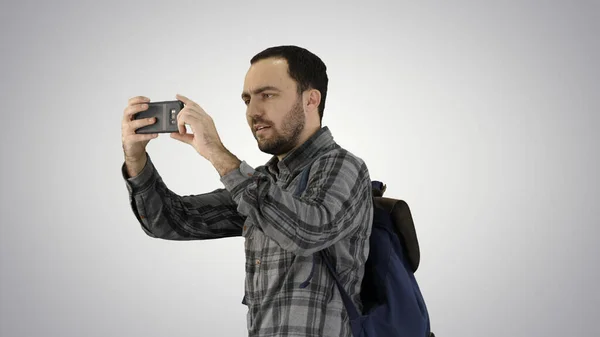 Schöner junger Mann trägt Rucksack und macht ein Foto von ihm — Stockfoto