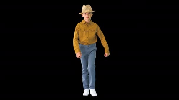 Menino de camisa ajustando o chapéu de palha enquanto caminhava e olhava para a câmera, Alpha Channel — Vídeo de Stock