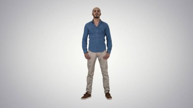 Katı bir adam dikilip kameraya bakıyor..