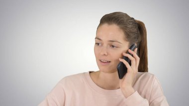 Gradyan arka planda cep telefonuyla konuşan güzel bir kadın.