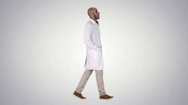 Doktor ellerini cebine sokup, arka planda yürüyor..