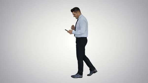 L'uomo che cammina guardando al telefono e facendo il gesto di vittoria su pendenza — Foto Stock