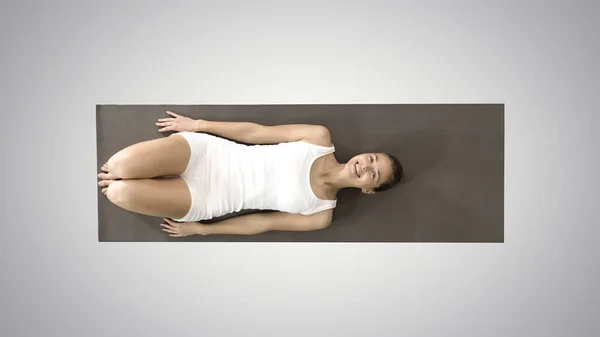 Yoga kvinna skrattar lägger på golvet på lutning bakgrund. — Stockfoto