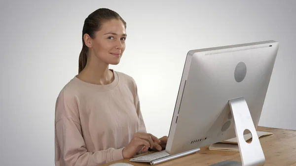 Mujer rubia usando el ordenador y teniendo una idea sonriendo en gradie — Foto de Stock