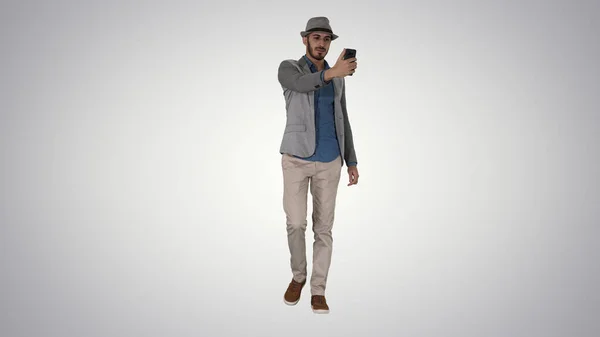 Homem árabe na roupa casual andando e fazendo selfie em g — Fotografia de Stock